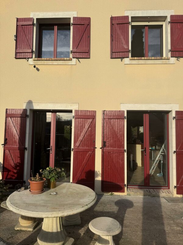 Détail menuiserie aluminium K-Line bicolore rouge et blanc adaptée au charme de la bâtisse
